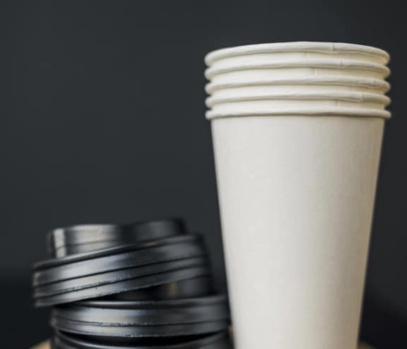 Stacked coffee cups and lids on coaster