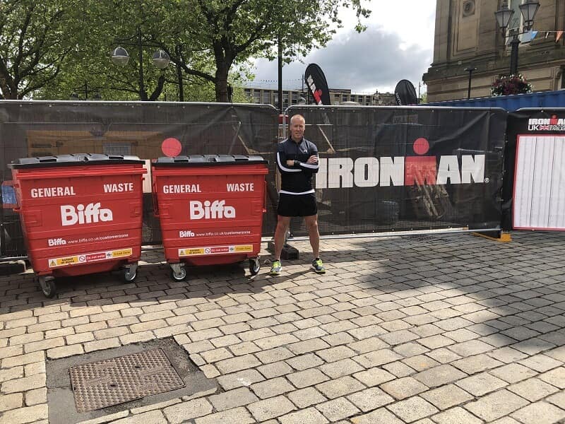 Nigel Carr next to Biffa bins and Ironman logo