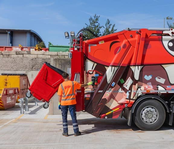 Employee loading bin into the back of truck