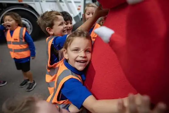 Girl hugging wasteater mascot