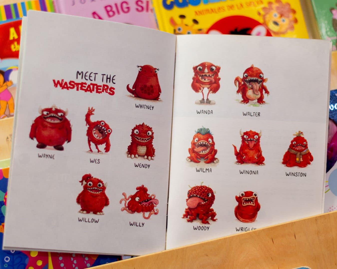 Open wasteater storybook sat on childrens bookshelf, page  shown is meet the wasteaters page showing all the wasteaters