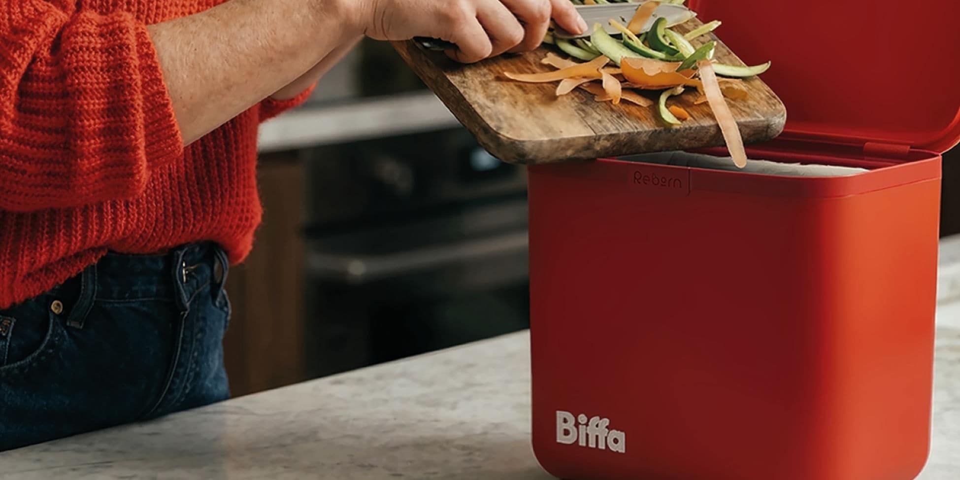 Food being scrapped into red kitchen caddy