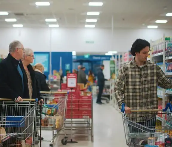 Man and couple in Community shop aisle