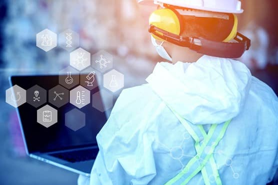 Male in hazmat suit with laptop