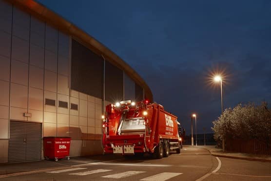 Biffa truck and bin outside building at night