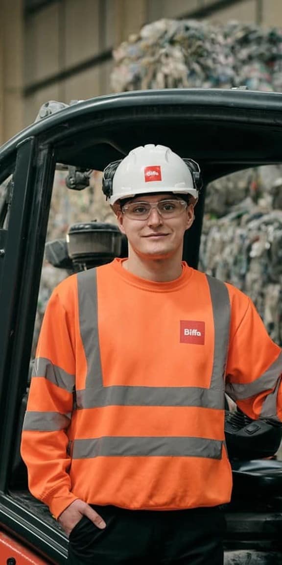 Biffa employee standing next to forklift