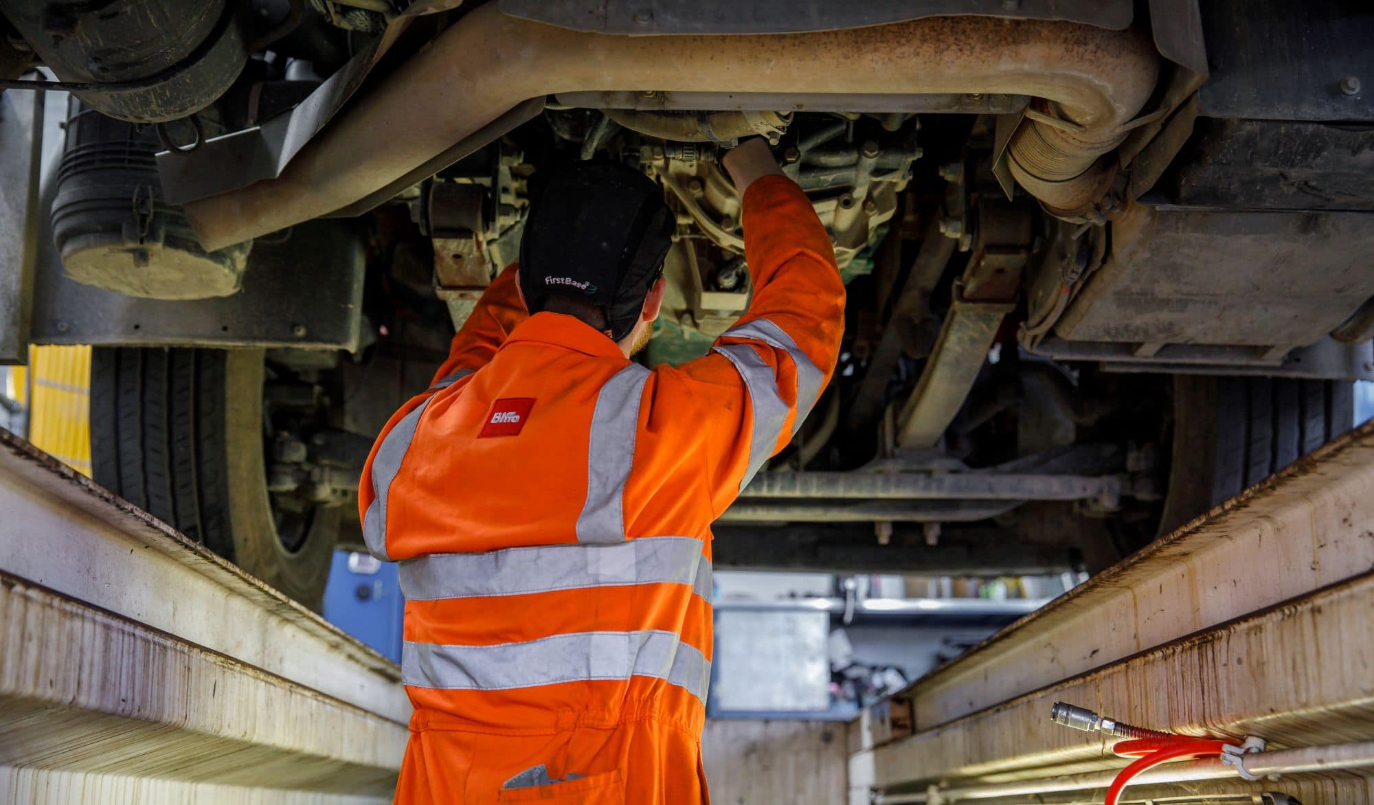 Employee working on the bottom of a truck