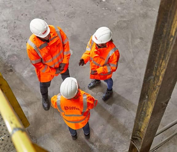 3 employees standing talking