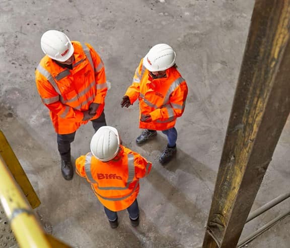 3 employees standing talking