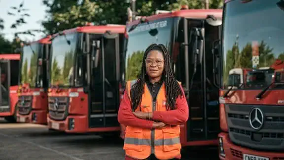 Female employee in front of waste vehicles