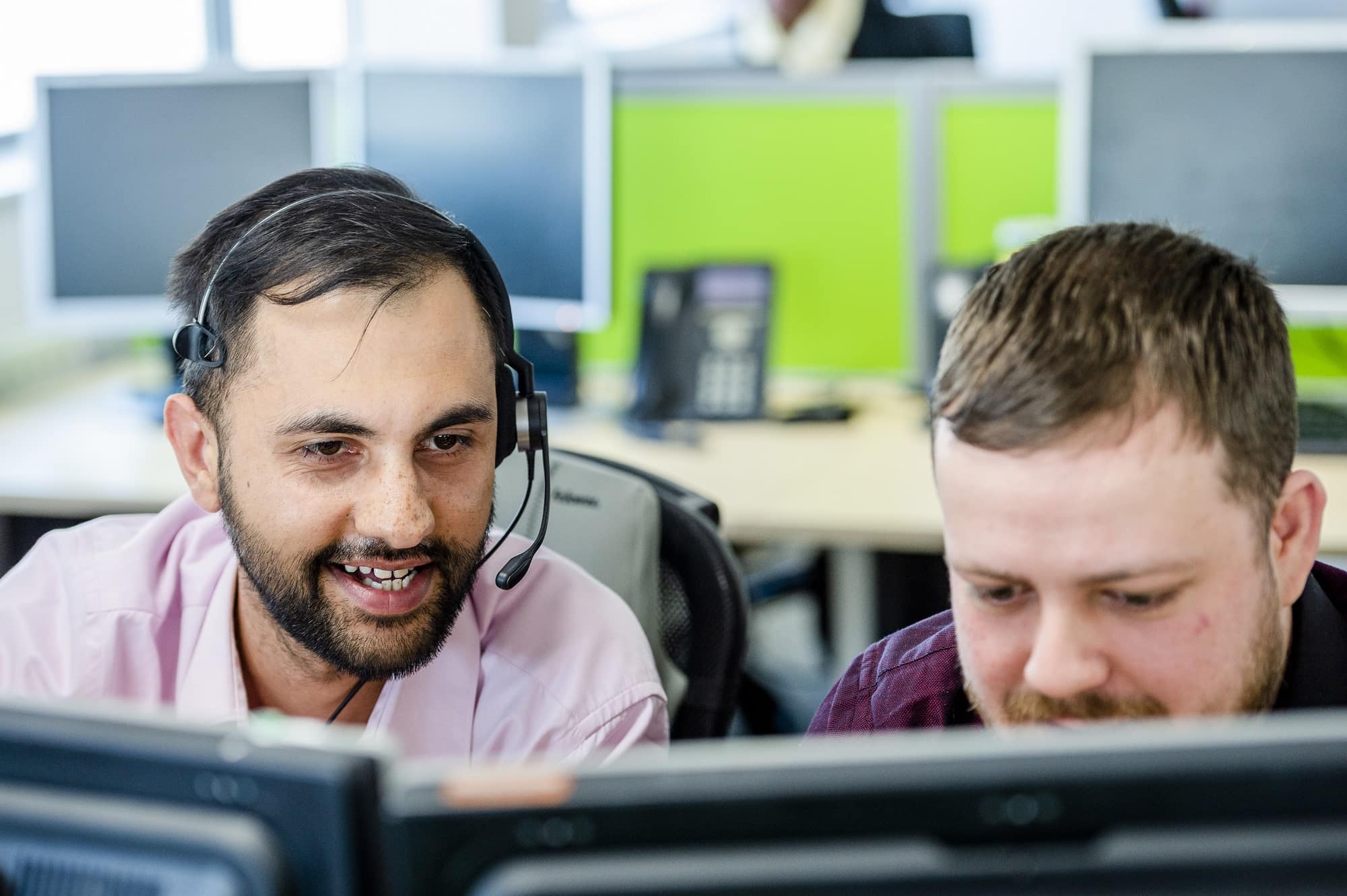 Two male employees with headsets