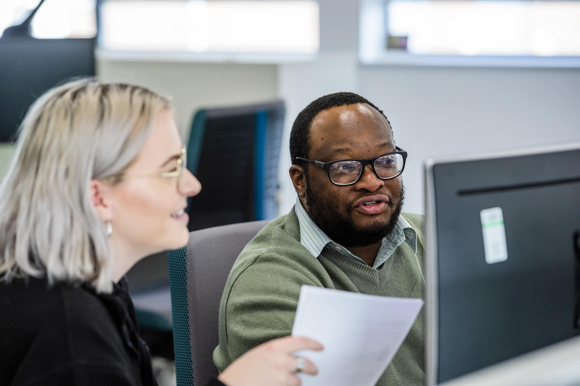Female and male co worker looking at monitor