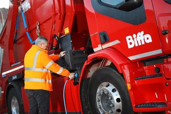 Man charging Biffa's first Volvo electric skip loader