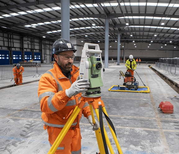 Surveyor and workers on a building site