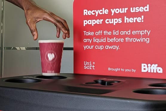 Man places single-use takeaway cup in Biffa recycling bin