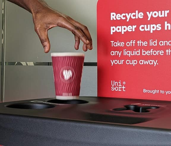 Man places single-use takeaway cup in Biffa recycling bin