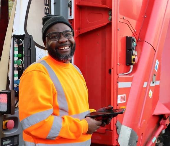 Employee smiling in front of a Biffa truck