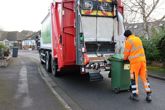 Employee loading bin into the back of truck