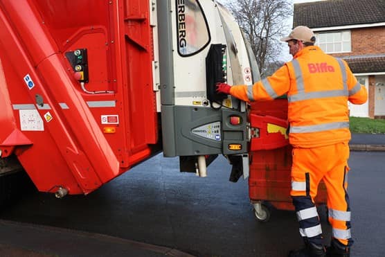 Employee loading bin into the back of truck