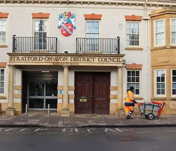 Bin man walking in front of Stratford-on-Avon District Council building