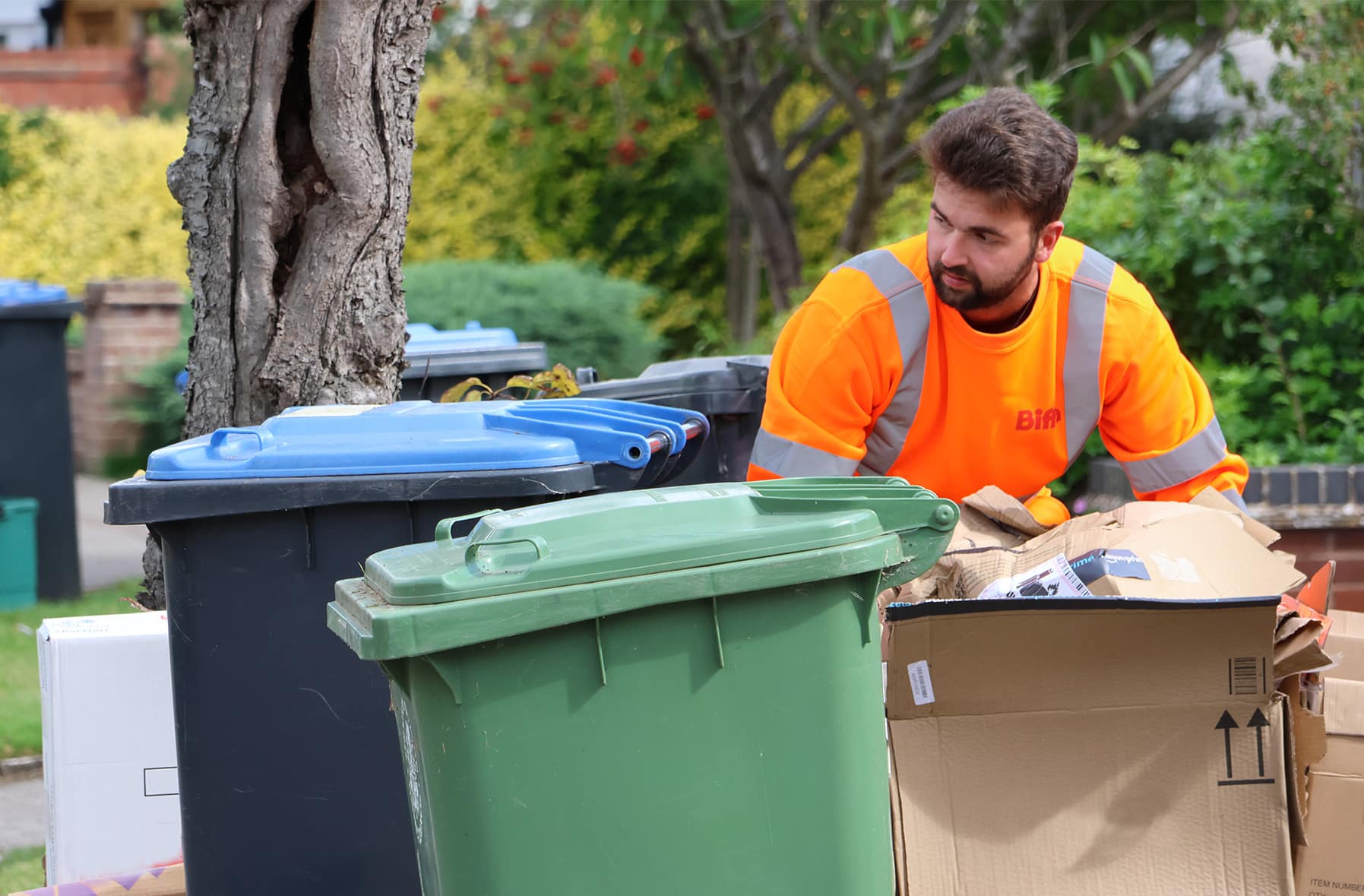 Employee with bin and cardboard waste