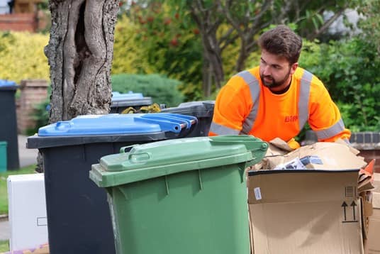 Employee with bin and cardboard waste