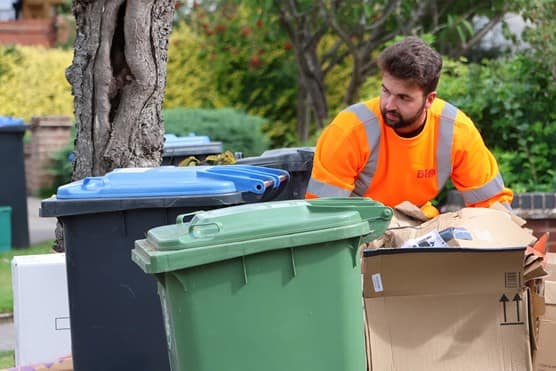 Employee with bin and cardboard waste