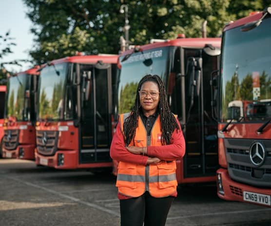Female employee in front of waste vehicles