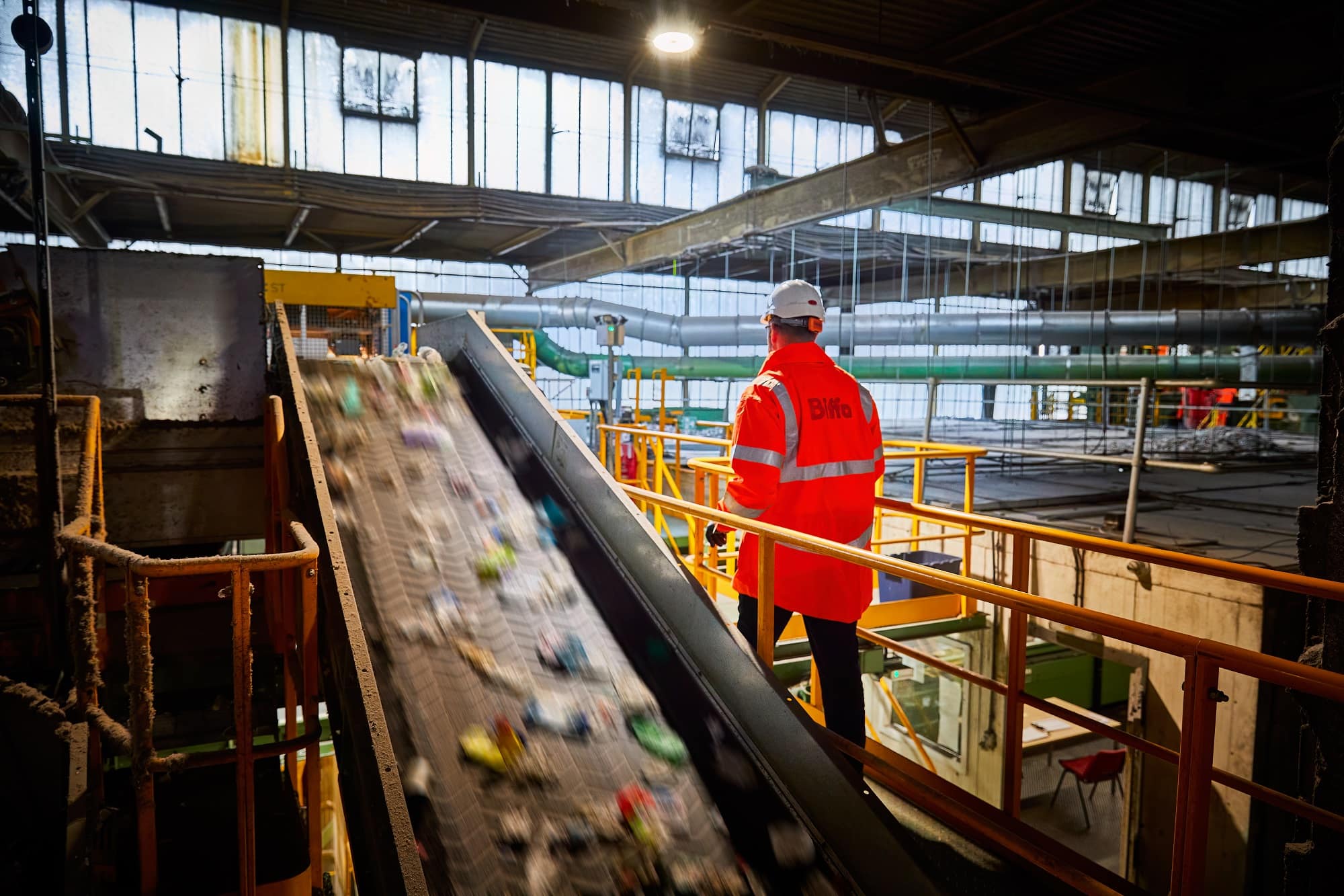 Biffa employee in high vis next to conveyor belt