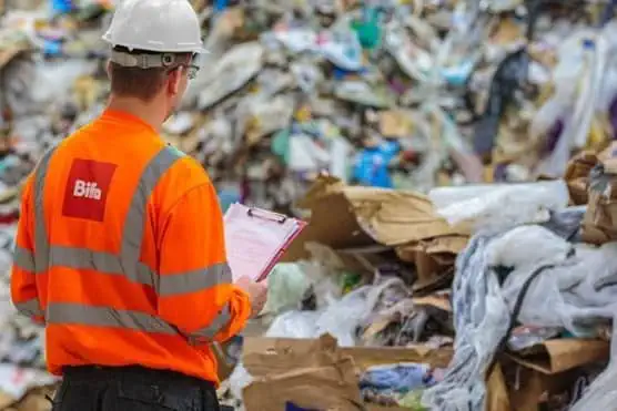 Person in Biffa high vis looking at mountain of waste