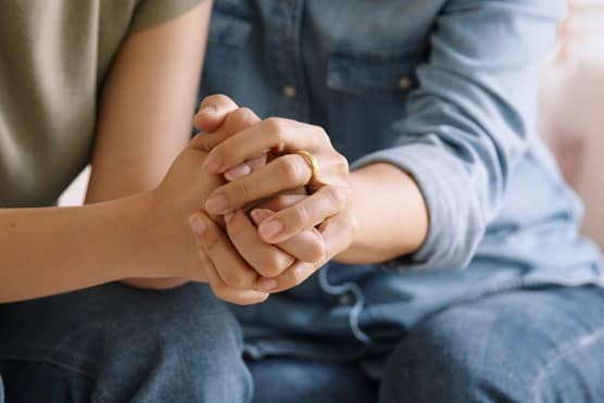 Person clutching hands of family member