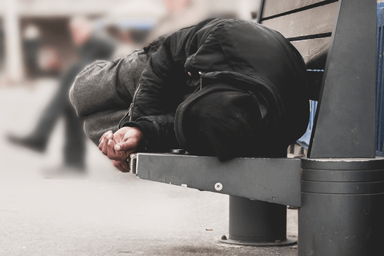 Homeless man sleeping on bench