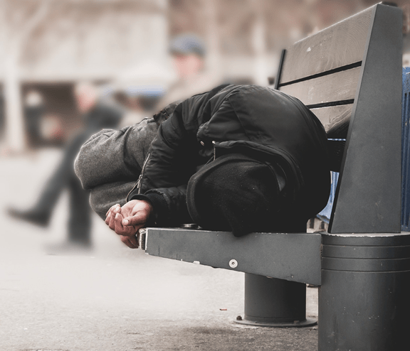 Homeless man sleeping on bench