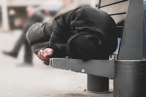 Homeless man sleeping on bench
