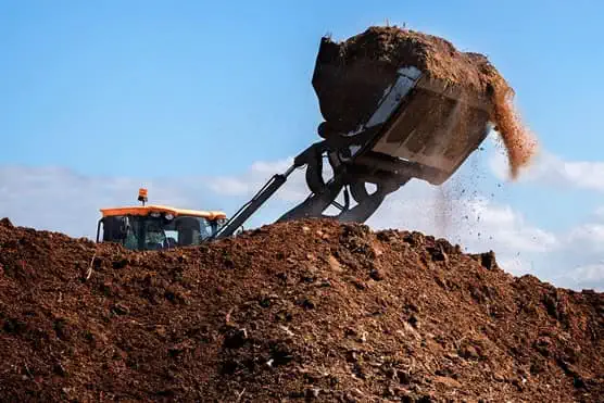 Excavator lifting soil from large amount