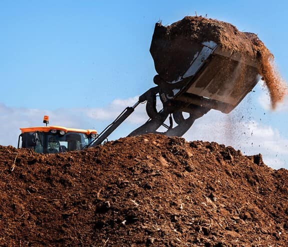 Excavator lifting soil from large amount